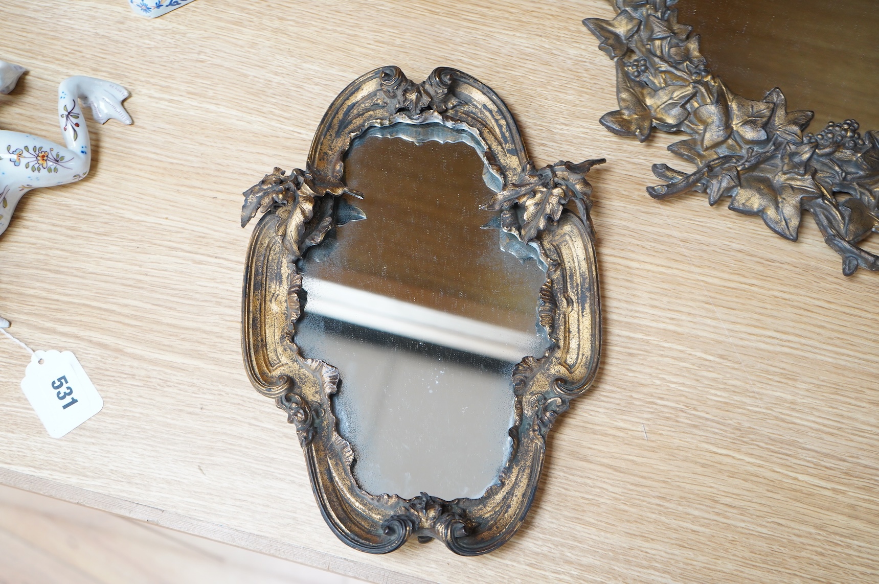 Two ornate oval gilt metal framed wall mirrors, largest 49cm